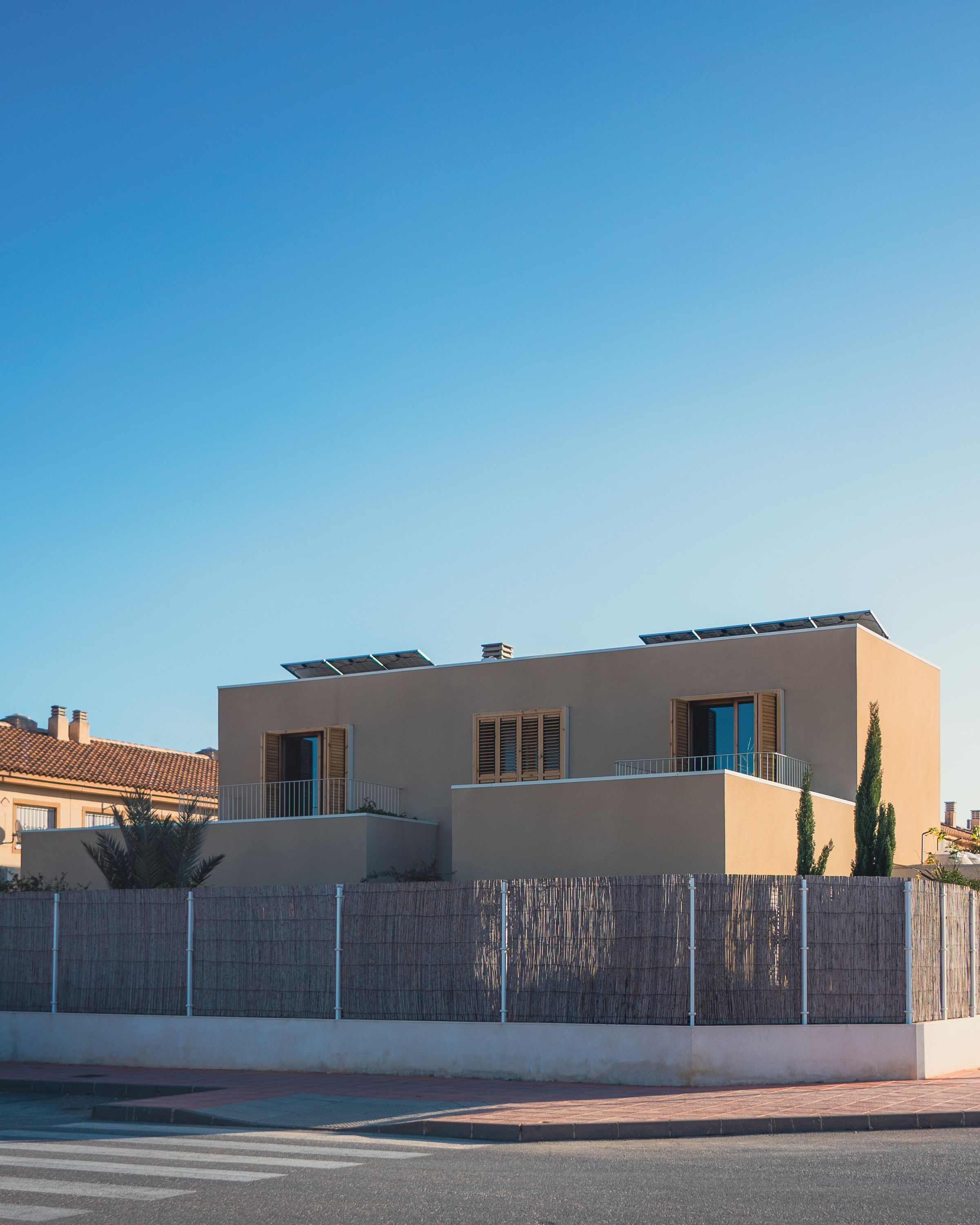 Maison à toit plat avec modules photovoltaïques posés sur la terrasse, ciel bleu