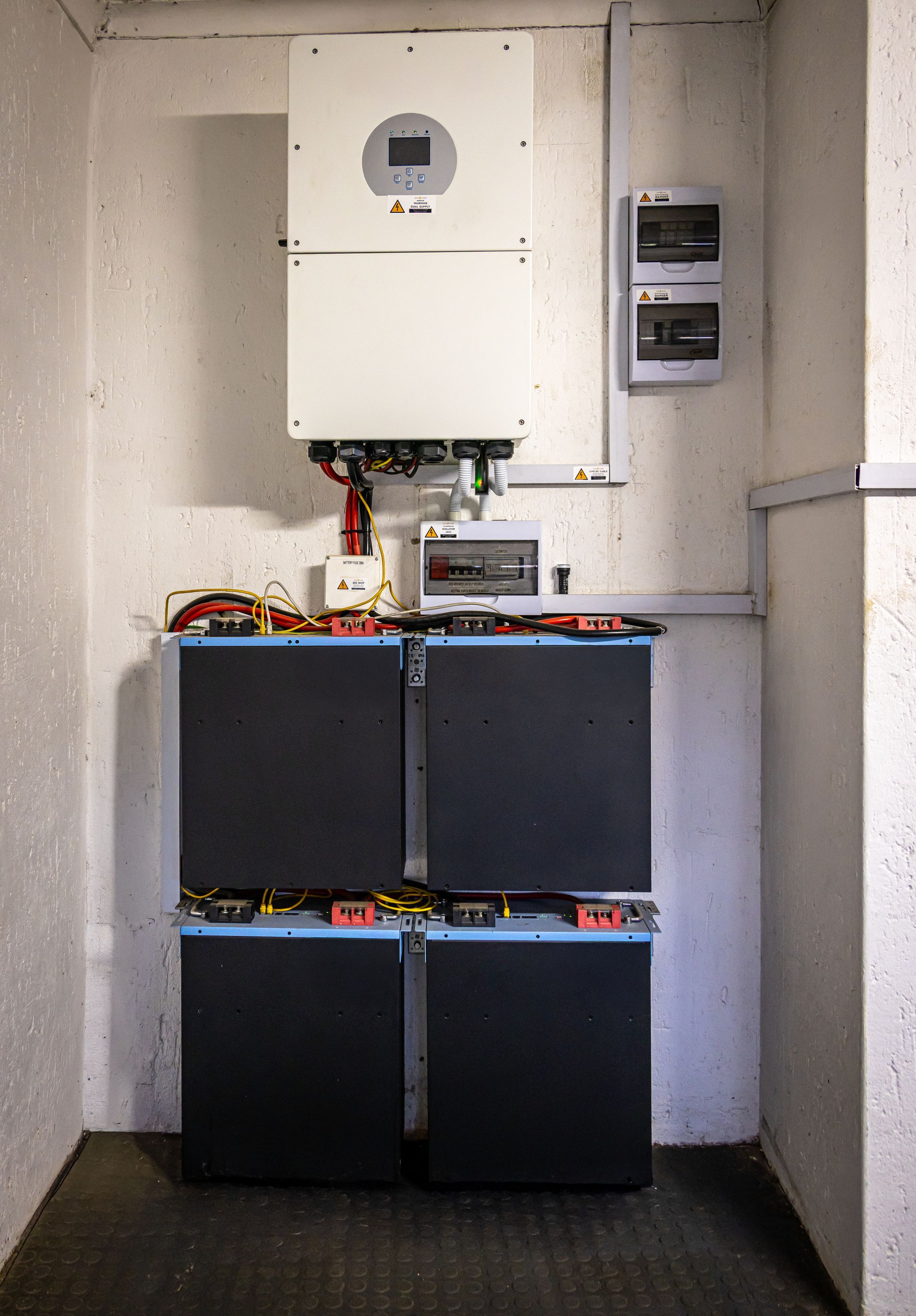Modules de batterie empilés sous un onduleur dans un local technique