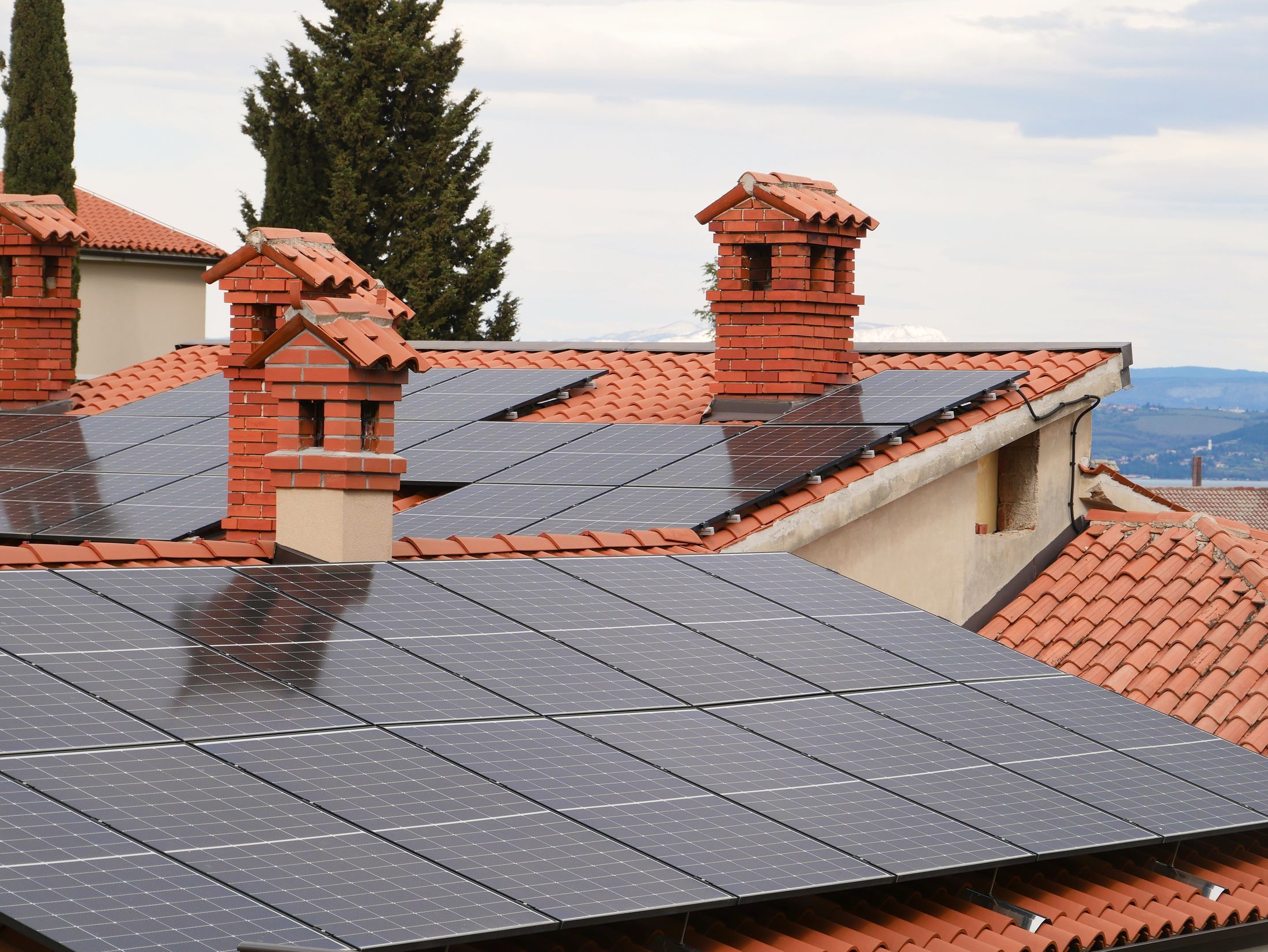 Toits en tuiles de plusieurs orientations couverts de modules photovoltaïques